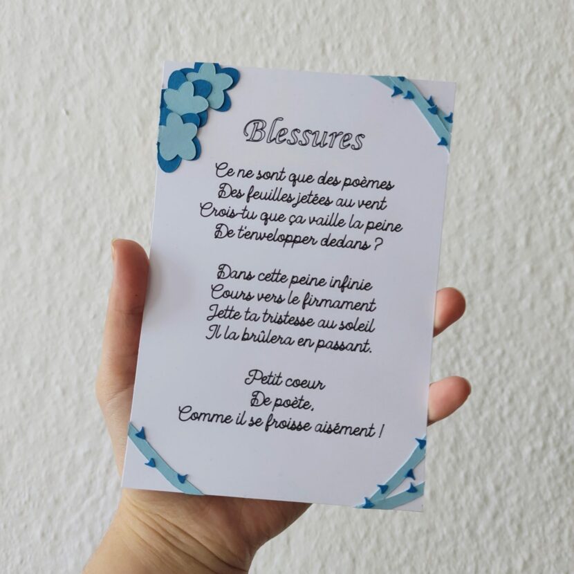 Carte fait main : elle est plus grande qu'une paume de main. Blanche avec des fleurs bleu et le poème écrit en noir.